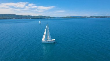Yat manzaralı, güzel adaların yakınında. Arka planda güzel bulutlar var. Denizde lüks bir yat..