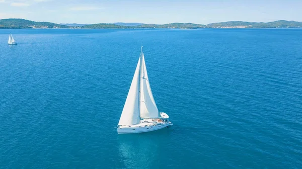 Aerial view of yacht sailing near beautiful Islands. Beautiful clouds in the background. Luxury yacht in the sea.