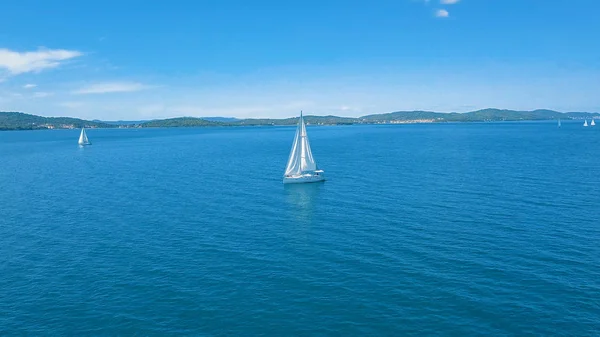 Vista aérea do iate que navega perto de belas ilhas. Lindas nuvens no fundo. Iate de luxo no mar. — Fotografia de Stock