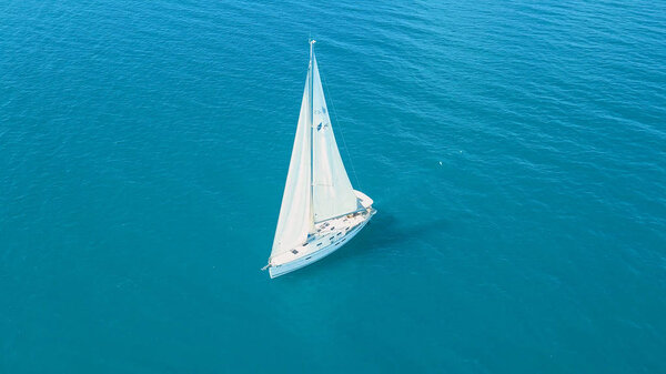 Вид с воздуха на яхту, плывущую вблизи красивых островов. Красивые облака на заднем плане. Яхта класса люкс в море.