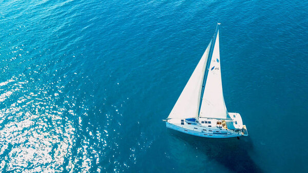 Вид с воздуха на яхту, плывущую вблизи красивых островов. Красивые облака на заднем плане. Яхта класса люкс в море.