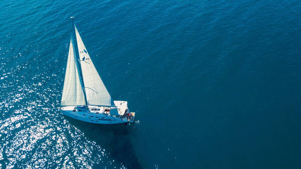 Вид с воздуха на яхту, плывущую вблизи красивых островов. Красивые облака на заднем плане. Яхта класса люкс в море.