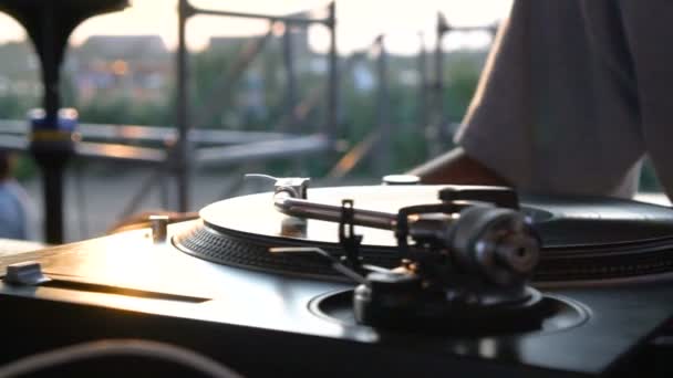 Mezclar y rayar, las manos de un DJ en vinilo y perillas de mezclador. Movimiento lento 120 fps. Disparando con gimbal. Puesta de sol . — Vídeos de Stock