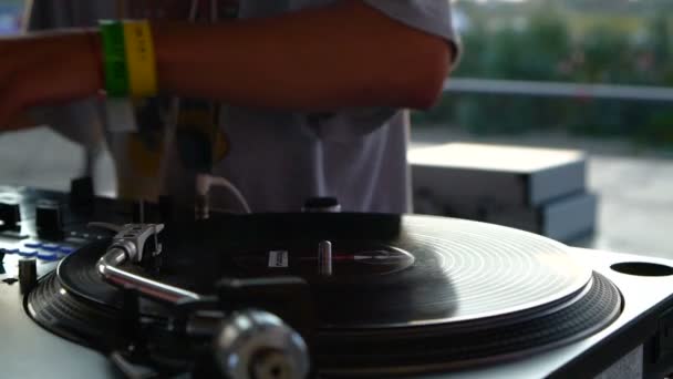 Misture e arranhe, mãos de um DJ em maçanetas de vinil e misturador. Movimento lento 120 fps. A disparar com o Gimbal. Pôr do sol . — Vídeo de Stock