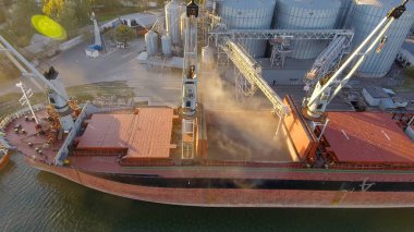 Aerial view of big grain elevators on the sea. Loading of grain on a ship. Port. Cargo ship clipart