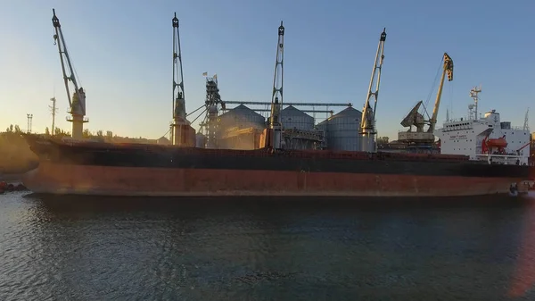 Vista aerea di grandi ascensori a grano sul mare. Carico di grano su una nave. Porto. Nave da carico Immagine Stock