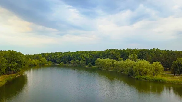 Drohnenflugaufnahmen aus der Luft: Rückflug über ruhigem Wasser und Wald im sanften Licht des Sonnenuntergangs. Magische Landschaft. — Stockfoto