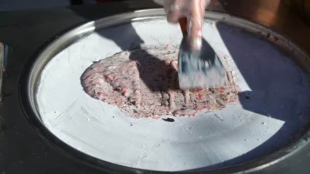 Ice cream rolls seller makes the portion of fried ice cream with biscuit and strawberries — Stock Video