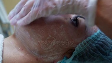 Kadın güzellik uzmanı kozmetik merkezinde kadın istemciye kozmetik yüz maskesi yapma. Yüz Temizleme