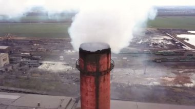 Hava görüntüsü. Endüstriyel borulardan atmosfere emisyon. Dumanlı borular İHA ile vuruldu. Yakın plan..
