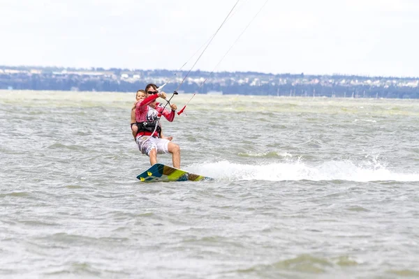 Papà e figlio stanno facendo kitesurf sul mare. Il figlio si aggrappa a Papas indietro — Foto Stock