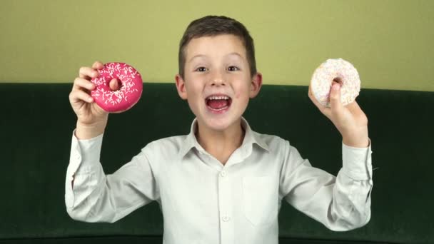 Маленький мальчик любит пончики — стоковое видео
