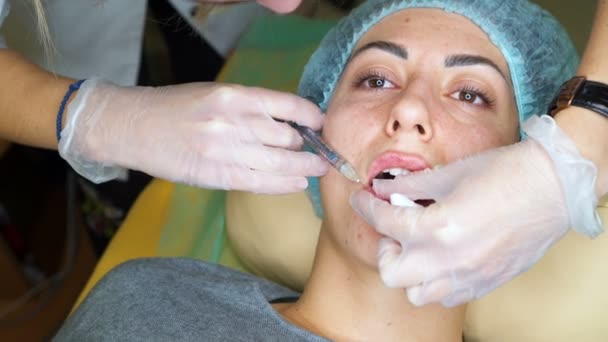 Kosmetolog göra injektion plast läppar. Ung kvinna på lip Augmentation i en klinik — Stockvideo