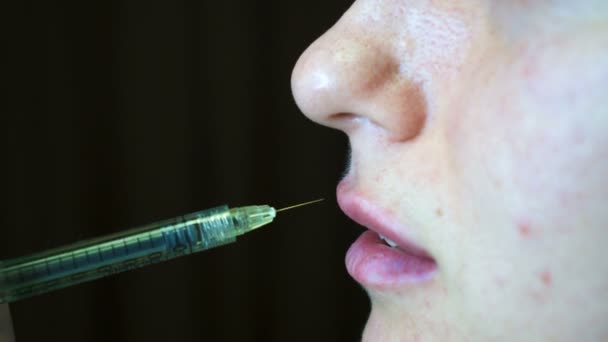 Schoonheidsspecialiste maken injectie kunststof lippen. Jonge vrouw op de lip vergroting in een kliniek — Stockvideo