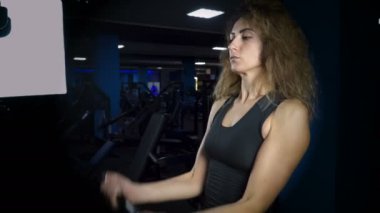 Spor salonunda egzersiz yapan genç bir kadın.