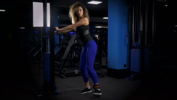 Mujer joven haciendo ejercicio en el gimnasio — Vídeos de Stock