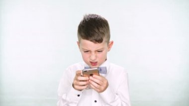 Erkek bebek başparmak aşağı ve tablet veya smartphone ile oynamak beyaz arka plan üzerinde gösterir