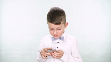 Erkek bebek başparmak yukarı ve tablet veya smartphone ile oynamak beyaz arka plan üzerinde gösterir