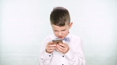 Erkek bebek başparmak aşağı ve tablet veya smartphone ile oynamak beyaz arka plan üzerinde gösterir