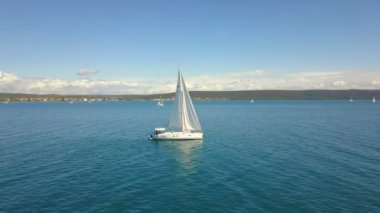Açık denizde yat gezintisi. Yelkenli. İHA 'dan gelen yat. Yat videosu. Yukardan yat. İHA 'dan yelkenliye. Yelkenli videosu. Rüzgarlı bir günde yat. Yat. Yelkenli..