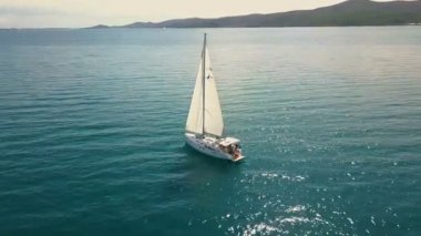 Açık denizde yat gezintisi. Yelkenli. İHA 'dan gelen yat. Yat videosu. Yukardan yat. İHA 'dan yelkenliye. Yelkenli videosu. Rüzgarlı bir günde yat. Yat. Yelkenli..