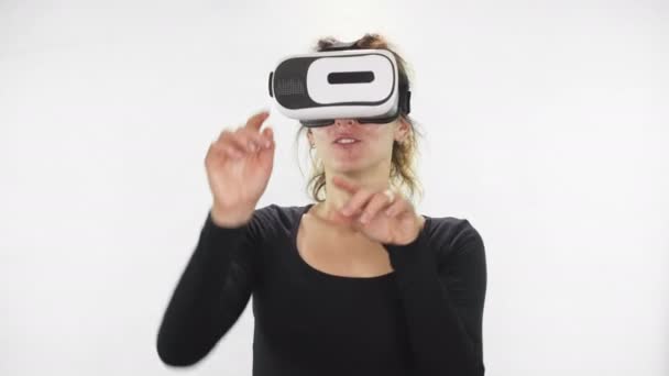 Будущее сейчас. Молодая женщина играет в VR-очки. Красивая женщина трогает что-то с помощью современных очков виртуальной реальности — стоковое видео