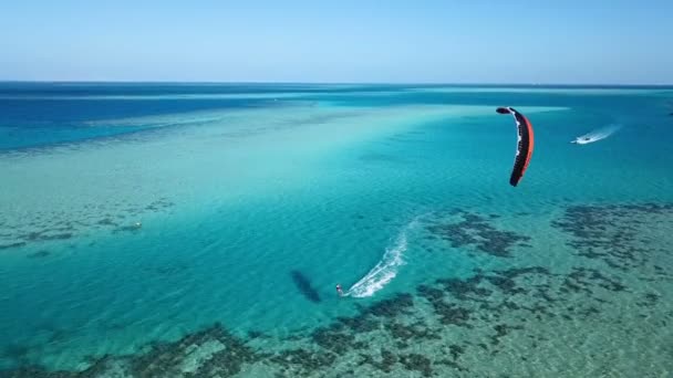 Flygfoto ung man kitesurfing i tropiska blå havet — Stockvideo
