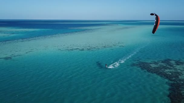 Vista aérea joven hombre kite surf en tropical azul océano — Vídeos de Stock