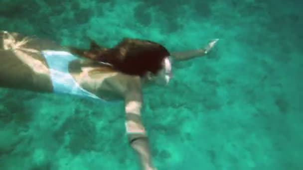 Mujer en traje de baño azul nadando bajo el agua en cámara lenta — Vídeos de Stock