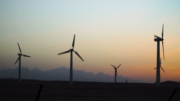 4 k piękna wiatrak turbin wykorzystanie energii wiatru czysty, ekologiczny, sylwetki w niebo zachód słońca z promieniami słonecznymi. Zielona energia. — Wideo stockowe