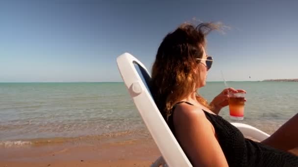 Jong meisje in bikini op strand met partij cocktail — Stockvideo