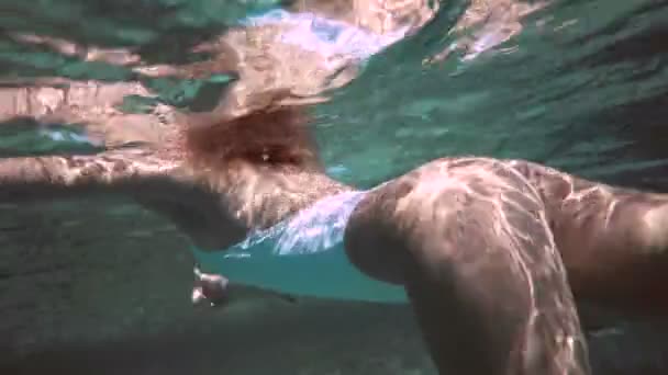 Kobieta w niebieski kąpielowy pływanie pod wodą w zwolnionym tempie — Wideo stockowe