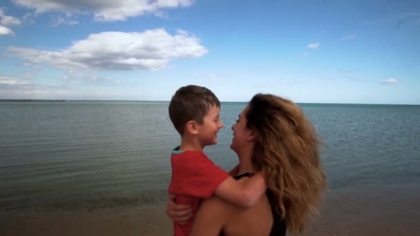 孩子和妈妈在沙滩上玩耍, 拥抱和亲吻。慢动作。120 fps — 图库视频影像