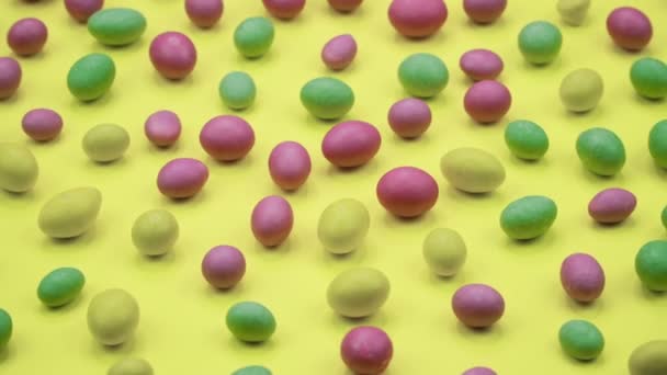 Makrovideo von leckeren knusprigen runden Bonbons isoliert auf gelbem Hintergrund. gelbe, orangefarbene, grüne, rosa und blaue Süßigkeiten rotieren. Echtzeit 4k — Stockvideo