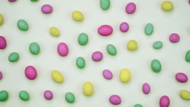Macro video van smakelijke krokante ronde snoepjes geïsoleerd op een witte achtergrond. Geel, oranje, groen, roze en blauwe snoepjes draaien. Realtime 4k — Stockvideo