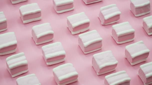 Helder en kleurrijk marshmallows close-up macro geschoten op een roze achtergrond. Roterende bovenaanzicht. — Stockvideo