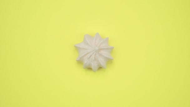 Marshmallow brilhante e colorido tiro macro close-up em um fundo amarelo. Vista superior rotativa . — Vídeo de Stock