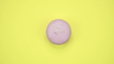 Döndürme: Renkli Macaroons dönen sarı bir arka plan üzerinde