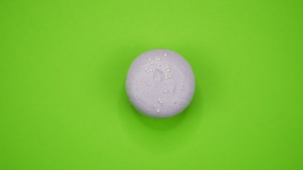 ROTACIÓN: Un colorido Macarrones están girando sobre un fondo verde — Vídeo de stock