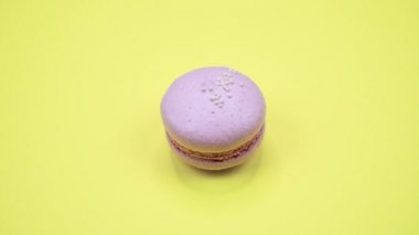 Döndürme: Renkli Macaroons dönen sarı bir arka plan üzerinde