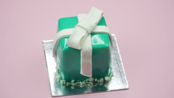Jasne i kolorowe ciasto prezent zbliżenie na różowym tle. Obracanie widoku z góry. — Wideo stockowe