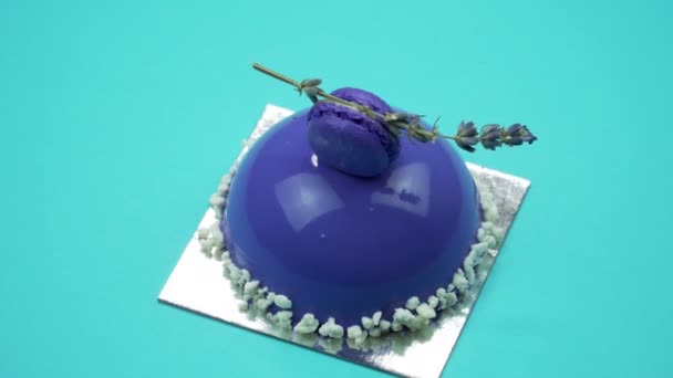 Gâteau lumineux et coloré gros plan sur un fond bleu. Rotation Vue de dessus . — Video