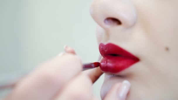 Primer plano de una atractiva chica de belleza haciendo maquillaje completo. Mujer aplicando labio rojo — Vídeo de stock