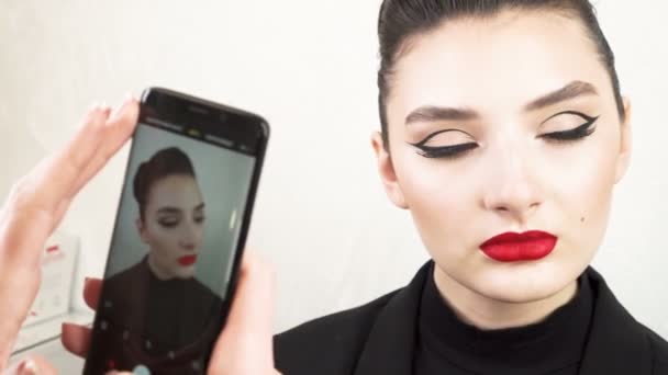 Primer plano de una atractiva chica de belleza haciendo maquillaje completo. Mujer aplicando labio rojo. Foto: — Vídeos de Stock