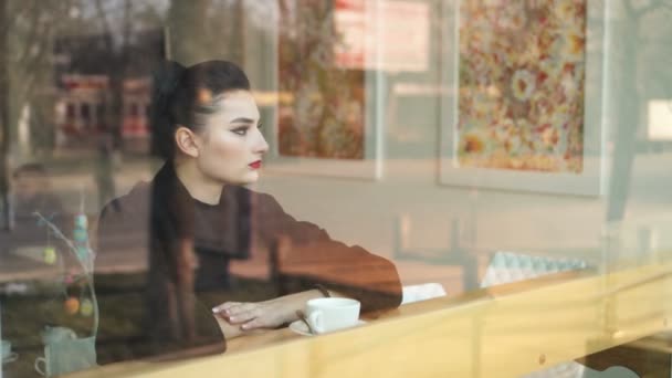 우울한 시간입니다. 젊은 비참 찾고 여자 창턱에 앉아서 천천히 커피 음료. — 비디오