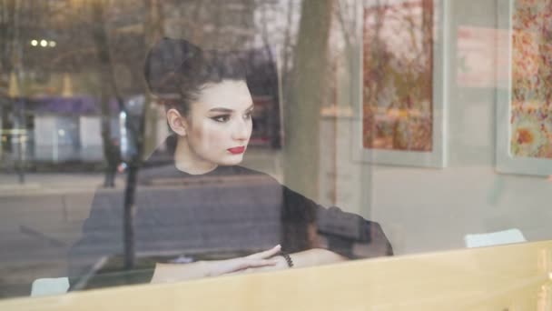 Melancholie tijd. Jonge ellendig ogende vrouw zit op de vensterbank en langzaam drinkt koffie. — Stockvideo