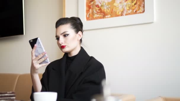 Jovencita en el restaurante. Mujer de negocios utiliza el teléfono inteligente . — Vídeos de Stock