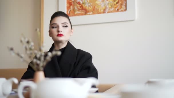 Belle fille qui boit du thé ou du café dans un café. Beauté modèle femme profiter de la tasse de boisson chaude et regarder par la fenêtre sur la ville . — Video