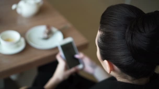 Вид сверху женщина пьет кофе на столе мобильный телефон — стоковое видео