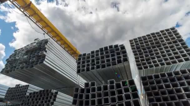 Tubos y tubos rectangulares metálicos, de acero o aluminio en el almacén. El lapso de tiempo. Nubes móviles — Vídeo de stock